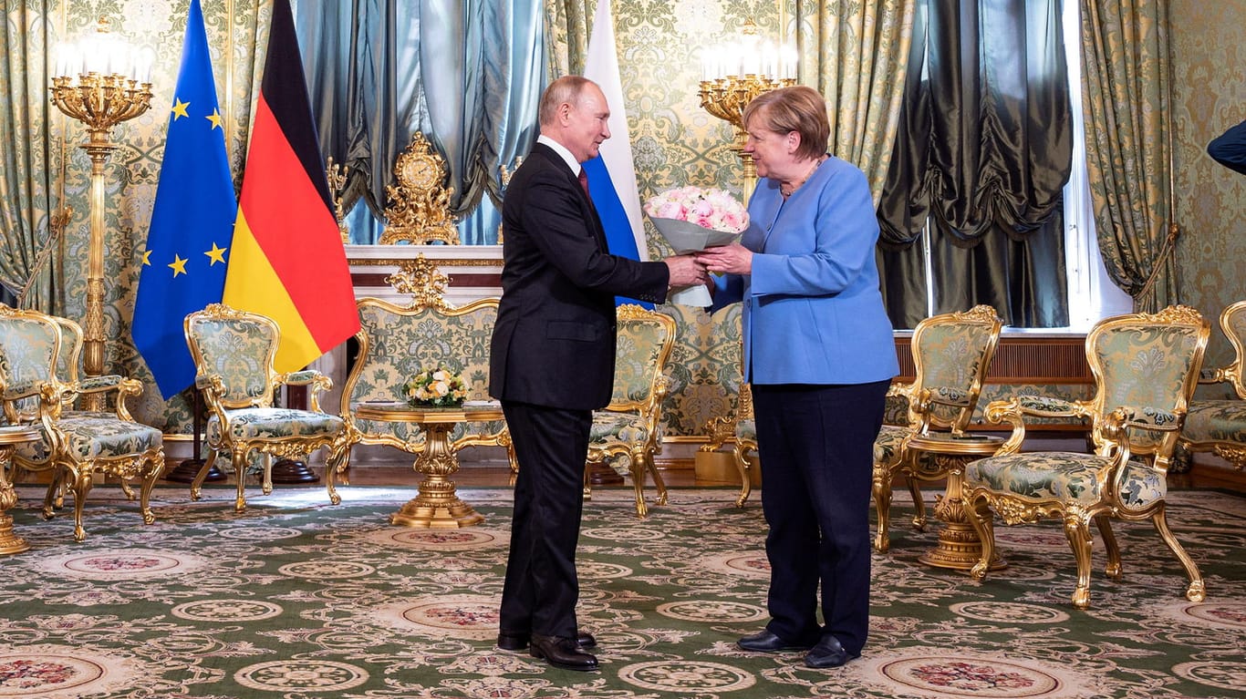 Russlands Präsident Wladimir Putin (l.) überreicht Bundeskanzlerin Angela Merkel einen Blumenstrauß: Die Kanzlerin ist in Moskau eingetroffen.