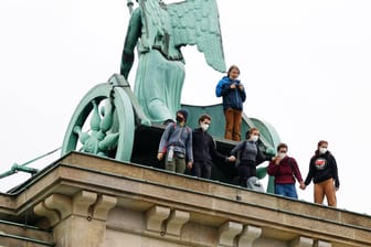 Klimaschutz-Aktivisten am Freitag auf dem Brandenburger Tor. Sie wurden von Beamten entfernt.