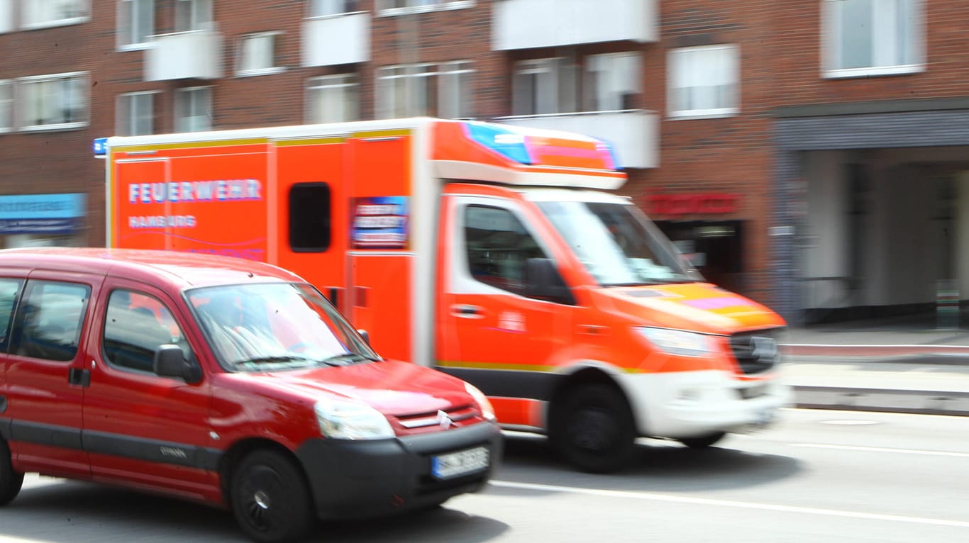Ein Rettungswagen der Feuerwehr Hamburg rast eine Straße hinauf (Symbolbild): In Hamburg ist es zu einem schweren Arbeitsunfall gekommen.