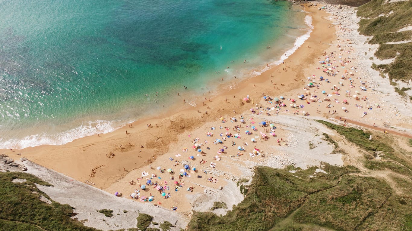 Strand in Spanien: Deutsche, die in Spanien Urlaub machen wollen, benötigen nun einen negativen Coronatest – es sei denn, sie sind geimpft oder genesen.