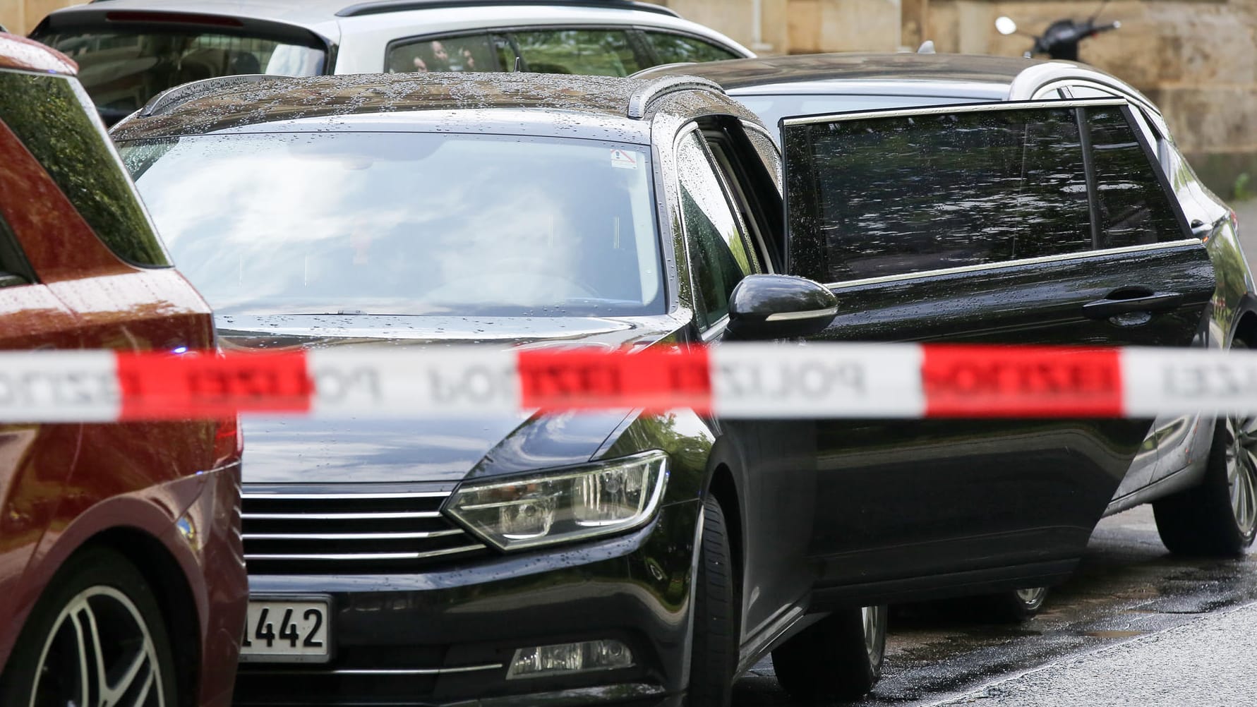 Ein Fahrzeug mit einer offenen Tür steht innerhalb einer Polizeiabsperrung: Es könnte sich dabei um das Fahrzeug handeln, aus dem mehrere Personen festgenommen worden waren.