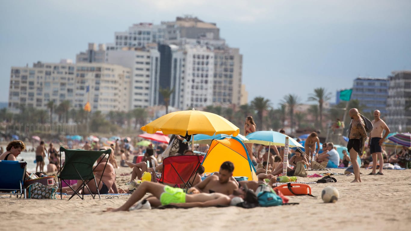 Urlauber vergnügen sich am Strand an der Costa Brava (Archivbild). Die Küstenregion ist kein Hochrisikogebiet mehr.