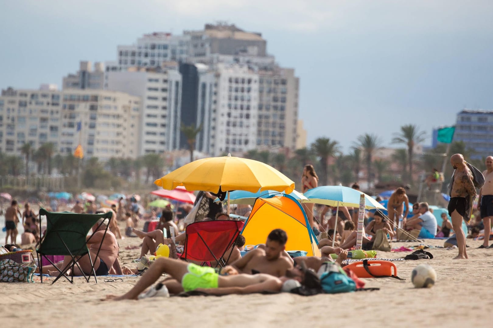 Urlauber vergnügen sich am Strand an der Costa Brava (Archivbild). Die Küstenregion ist kein Hochrisikogebiet mehr.