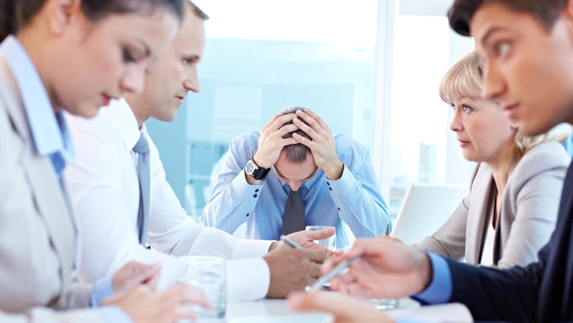 Eine Gruppe gestresster Mitarbeiter beim Meeting. Wie Stress empfunden wird, ist bei Frauen und Männern unterschiedlich.