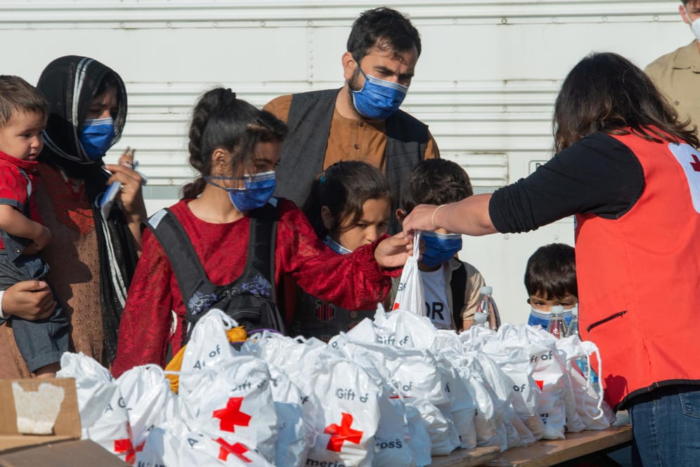 Eine Helferin des Roten Kreuzes versorgt eine aus Afghanistan evakuierte Familie am US-Militärstützpunkt Ramstein: Rund 4.000 Menschen könnten nun auf weiteren US-Stützpunkten untergebracht werden.