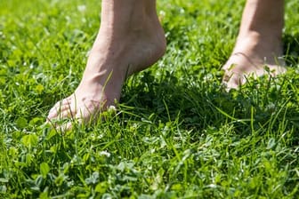 Schuhe aus: Gras ist ein perfekter Untergrund für die ersten Barfuß-Gehversuche.