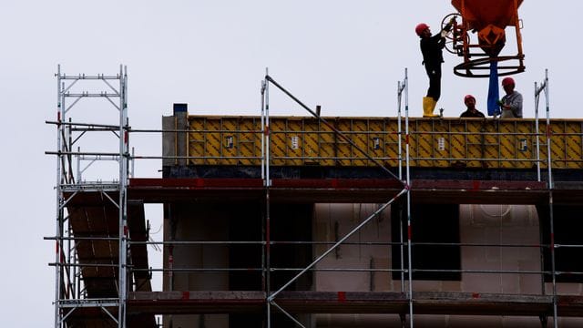 Arbeiter stehen auf einer Baustelle eines Wohngebäudes