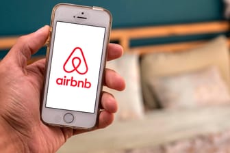 Ein Handy mit geöffneter Airbnb-App (Symbolbild): Das Portal will geflüchteten Afghanen in den USA und in anderen Ländern zu einer kostenlosen Unterkunft verhelfen.