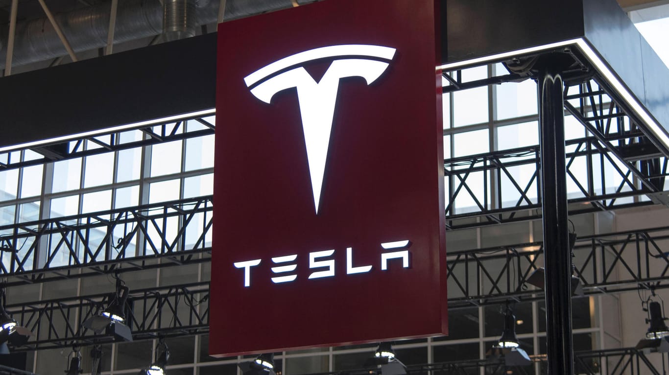Tesla-Logo an einem Messestand in China (Symbolbild): Der Autohersteller will auch auf dem Energiemarkt mitreden und bietet nun einen Stromtarif in Deutschland an.