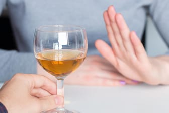 Eine Frau lehnt angebotenen Alkohol ab: Nach dem Entzug sollten alkoholkranke Personen lebenslang abstinent bleiben.