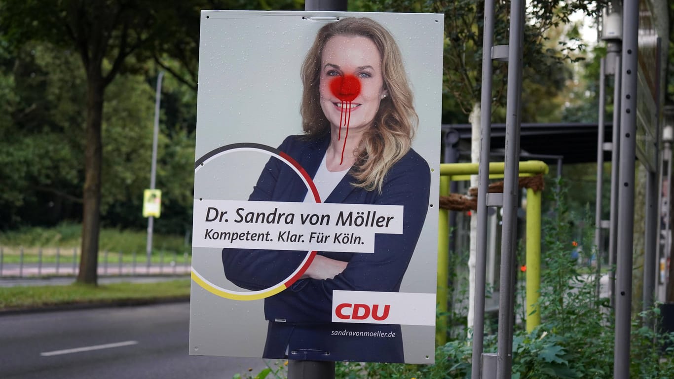 Ein beschmiertes CDU-Wahlplakat in Köln Junkersdorf: Derzeit sind 67 Strafanzeigen zu Vandalismus bei Wahlplakaten bei der Kölner Polizei eingegangen.