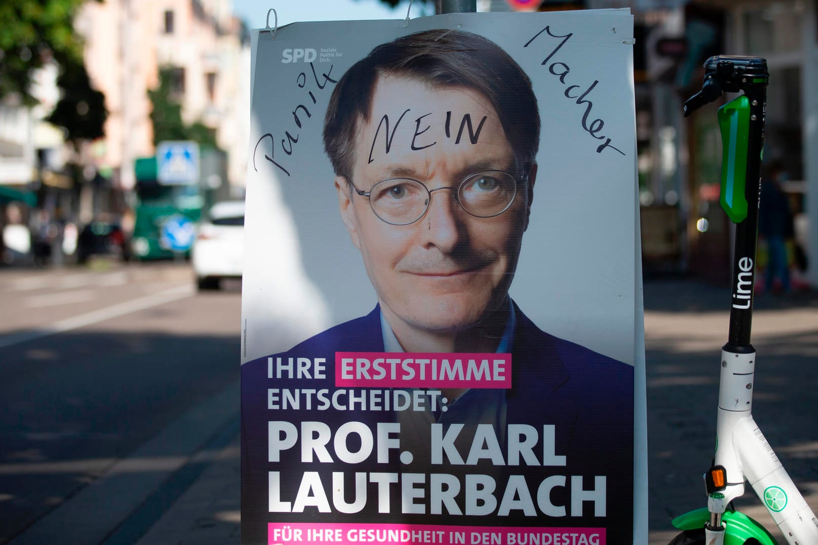 Ein beschmiertes Wahlplakat der SPD mit Karl Lauterbach: "Das habe ich so noch nicht gesehen", sagt Lauterbach zum Plakat-Vandalismus in der Stadt.