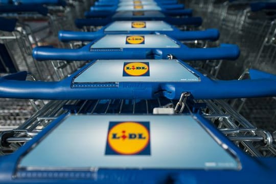 Einkaufswagen stehen vor einer Filiale des Lebensmitteldiscounters Lidl.