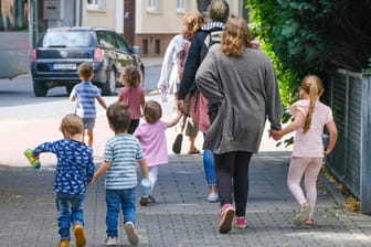 Eine Kita-Gruppe mit Erzieherinnen macht einen Ausflug (Symbolbild): In Leverkusen infizieren sich zunehmend Kinder und Jugendliche mit dem Coronavirus.