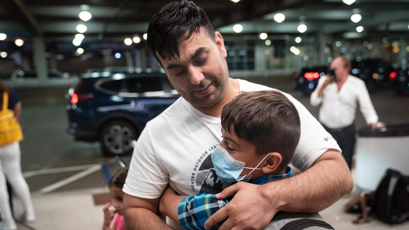 Ziaullah Qazizada umarmt seinen zehnjährigen Sohn auf dem US-Flughafen Minneapolis. Vier der sechs Mitglieder seiner Familie saßen nach einem Familienbesuch in Kabul fest.