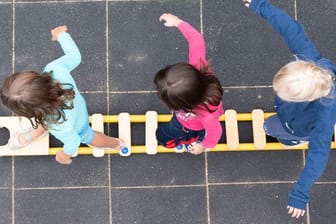 Kinder balancieren auf dem Spielplatz einer Kita