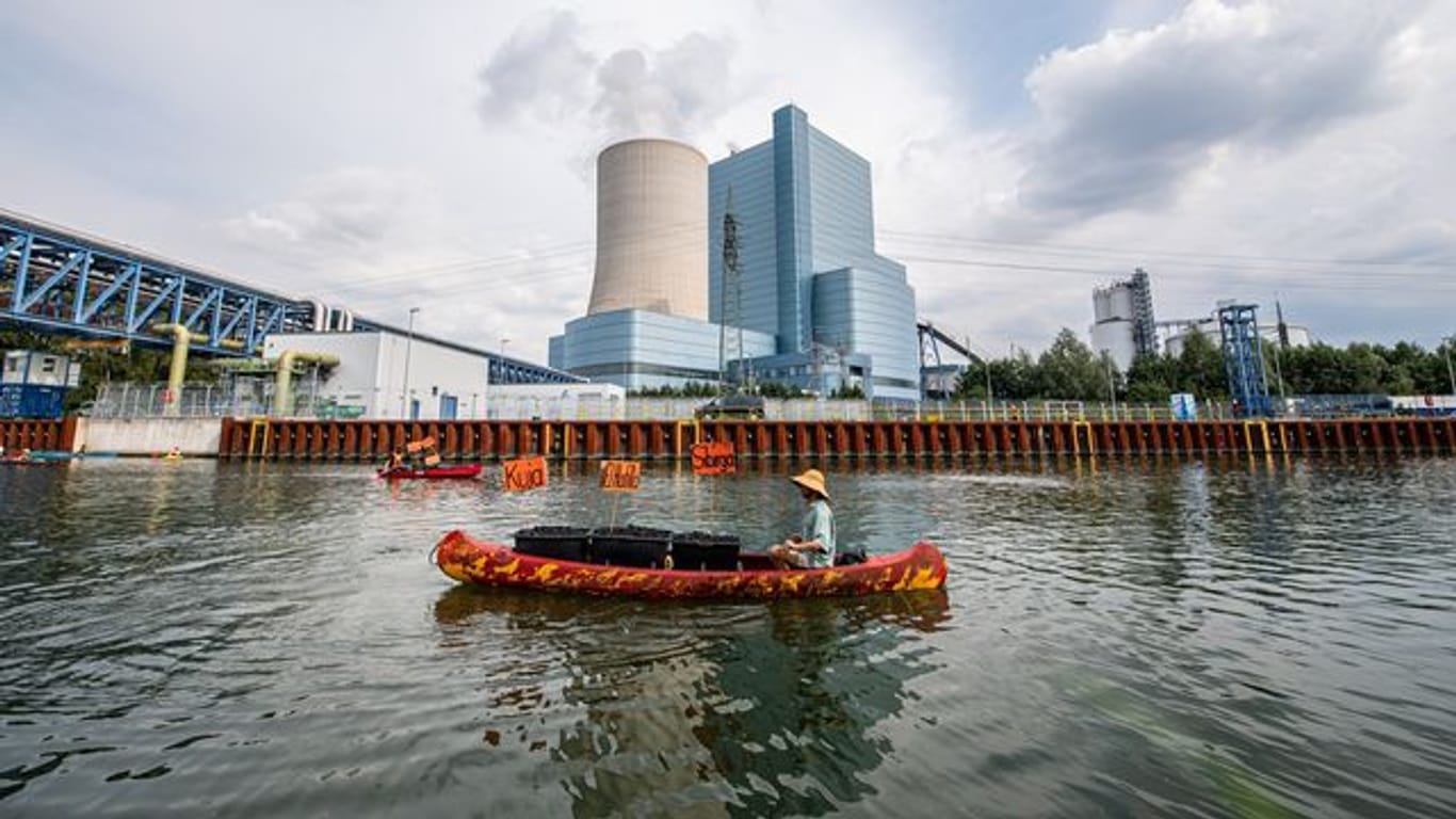 Ein Klimaaktivist paddelt mit seinem Kanu vor dem Kraftwerk