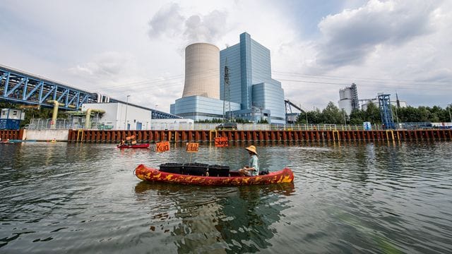 Ein Klimaaktivist paddelt mit seinem Kanu vor dem Kraftwerk Ein Klimaaktivist paddelt mit seinem Kanu vor dem Kraftwerk