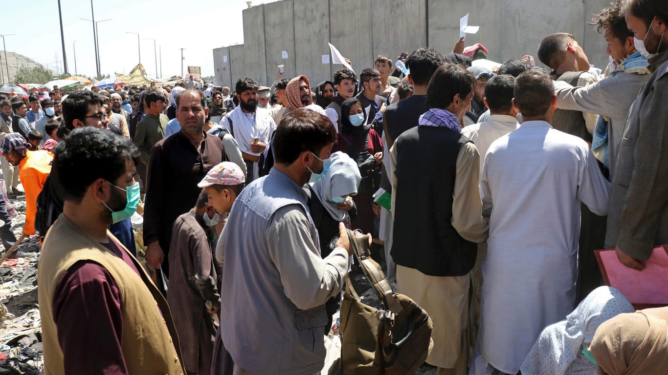 Flughafen Kabul: Hunderte Menschen halten ihre Dokumente hoch und versuchen verzweifelt, noch einen Platz in einer der Evakuierungsmaschinen zu bekommen.
