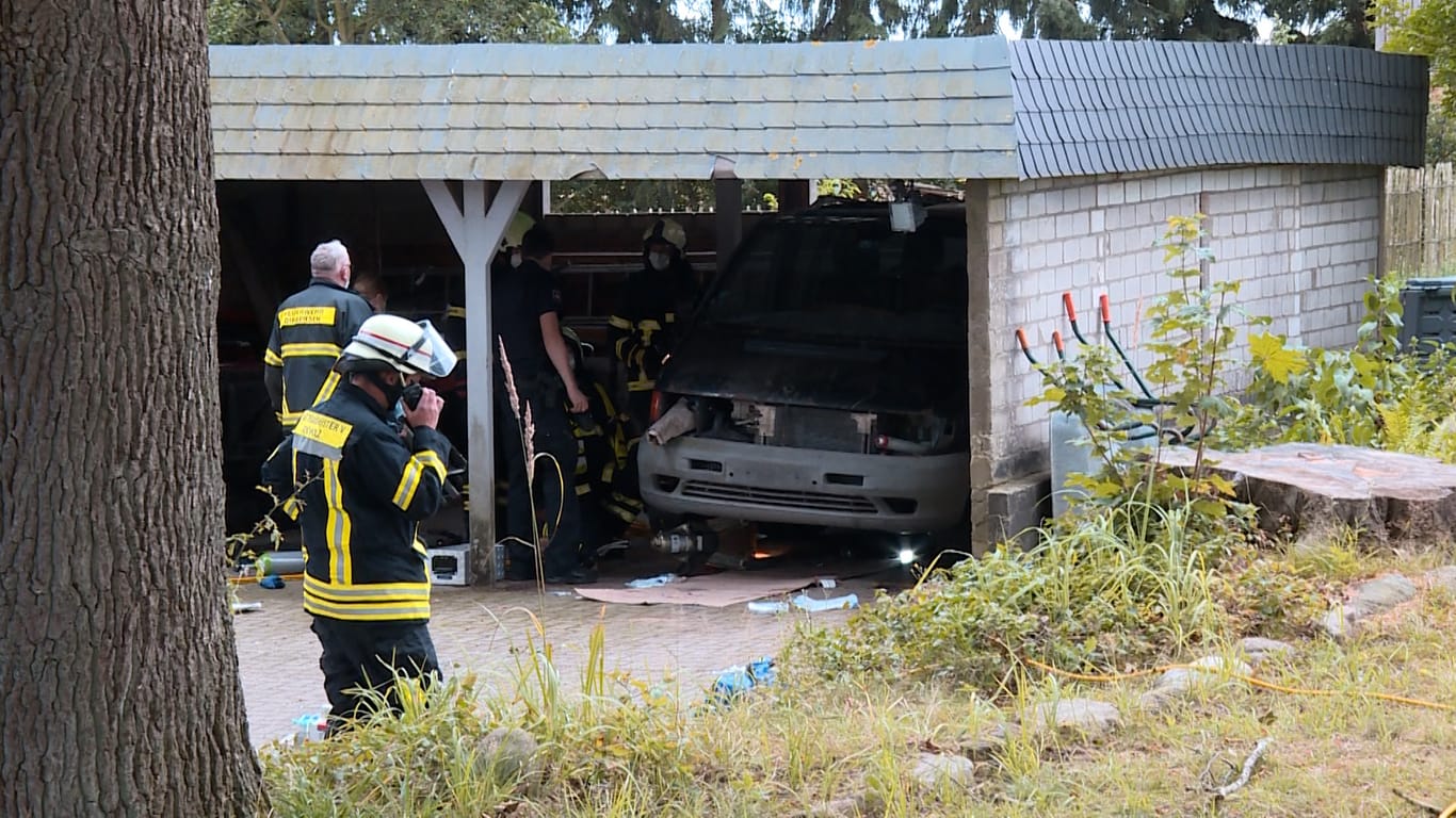 Die Feuerwehr am Carport: Der Wagen des Autoschraubers musste per Hebekissen angehoben werden.