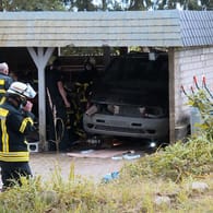 Die Feuerwehr am Carport: Der Wagen des Autoschraubers musste per Hebekissen angehoben werden.