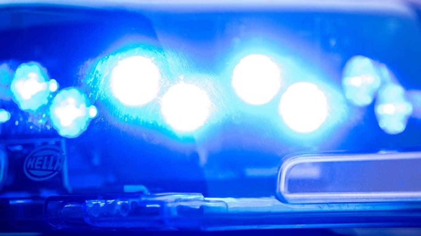 Ein Blaulicht leuchtet auf dem Dach einer Polizeistreife (Symbolbild): In Köln wird nach einem Mann gefahndet.