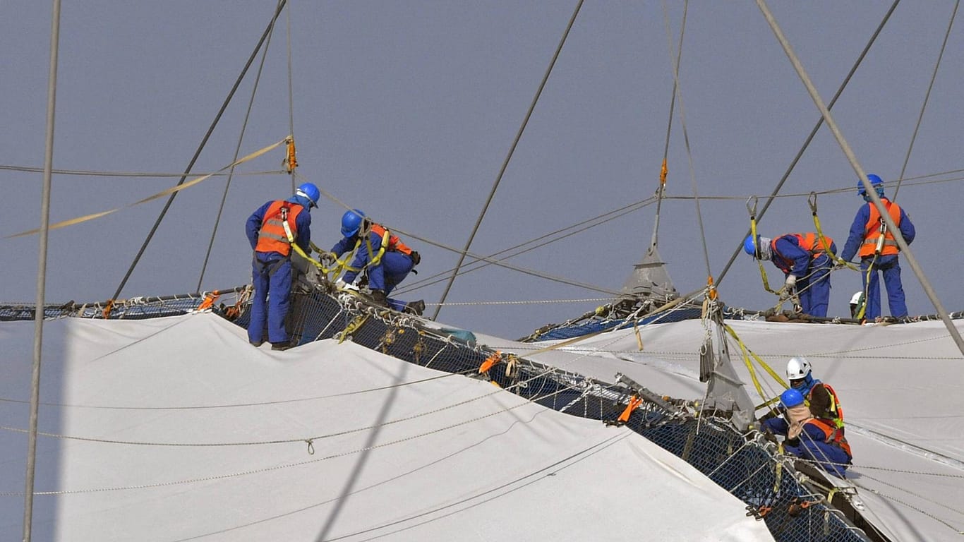 Arbeiter befestigen Planen am Khalifa Stadion in Doha (Archivbild). Katar hat Vorwürfe wegen schlechter Arbeitsbedingungen zurückgewiesen.
