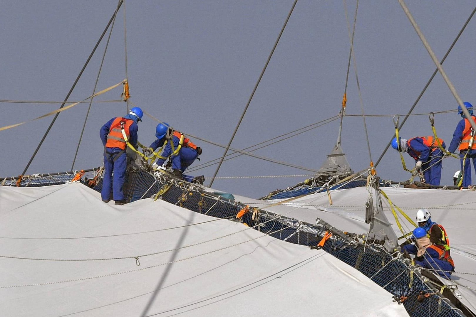 Arbeiter befestigen Planen am Khalifa Stadion in Doha (Archivbild). Katar hat Vorwürfe wegen schlechter Arbeitsbedingungen zurückgewiesen.