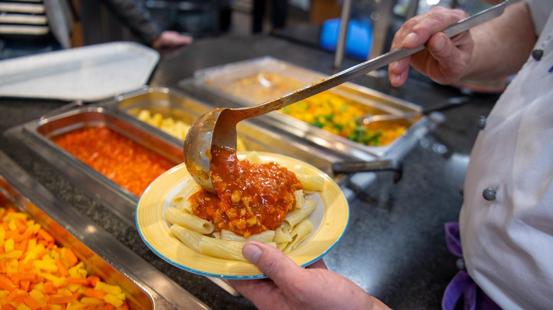 Ein Koch serviert ein veganes Gericht: Pflanzenbasierte Kost soll es bald in allen Berliner Mensen deutlich häufiger geben.