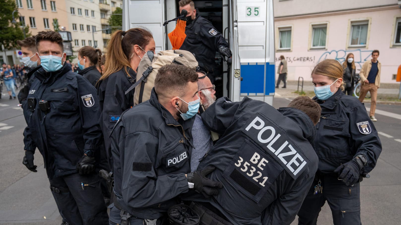 Polizisten halten an einem Polizeiwagen einen Teilnehmer der Demonstration fest, die aus Protest gegen die Corona-Politik veranstaltet wird: Es hat bereits mehrere Festnahmen gegeben.