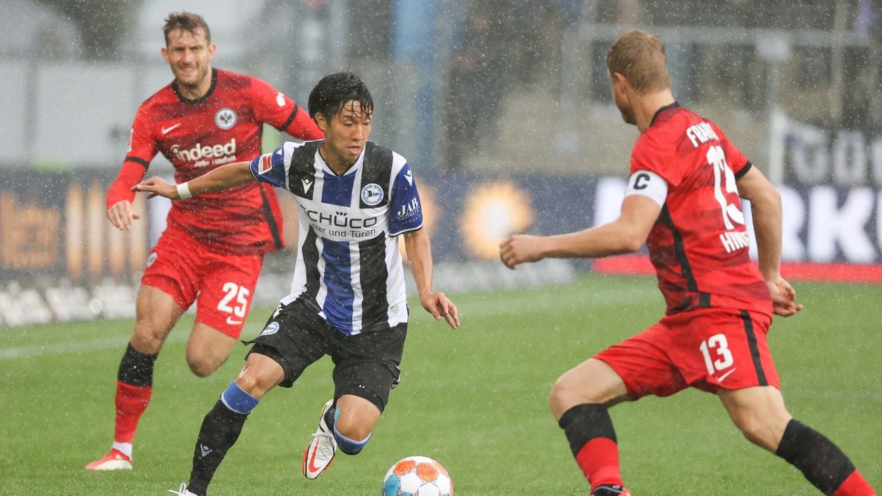 Bielefelds Masaya Okugawa (M) zieht im Dribbling gegen Frankfurts Martin Hinteregger (r) ins Eins gegen Eins.