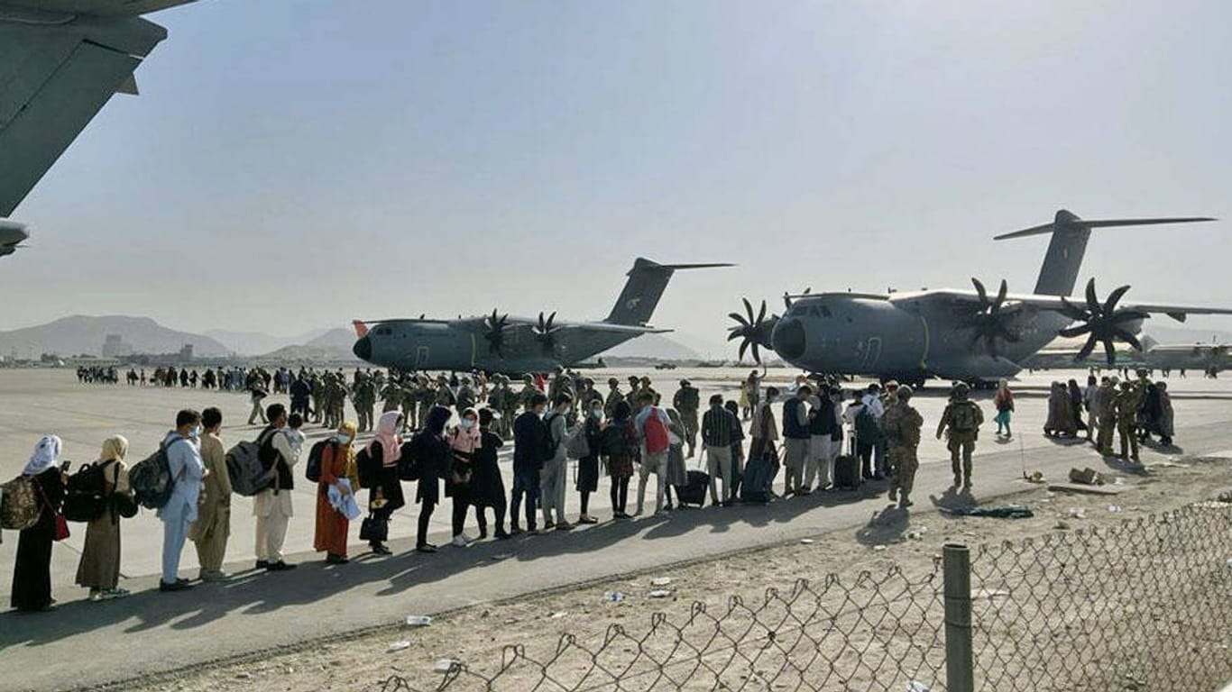 Menschen stehen am Freitag Schlange, um am Flughafen von Kabul in ein Flugzeug zu kommen. US-Tierretter bitten um Hilfe, um ebenfalls ausreisen zu dürfen.