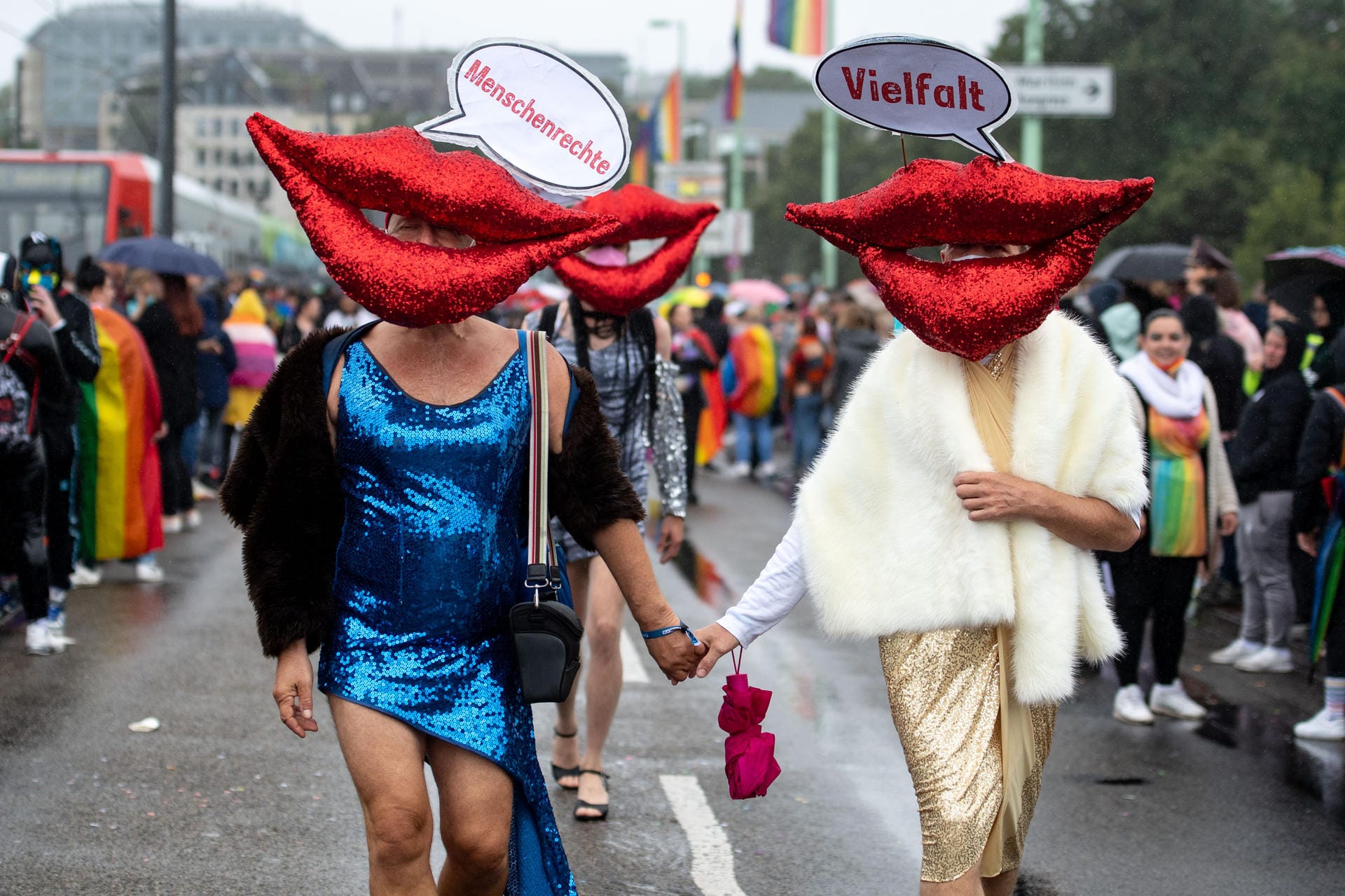 Teilnehmer der Parade tragen rote Münder mit Sprechblasen: "Menschenrechte" "Vielfalt" steht darauf.