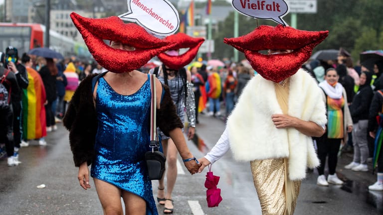 Teilnehmer der Parade tragen rote Münder mit Sprechblasen: "Menschenrechte" "Vielfalt" steht darauf.