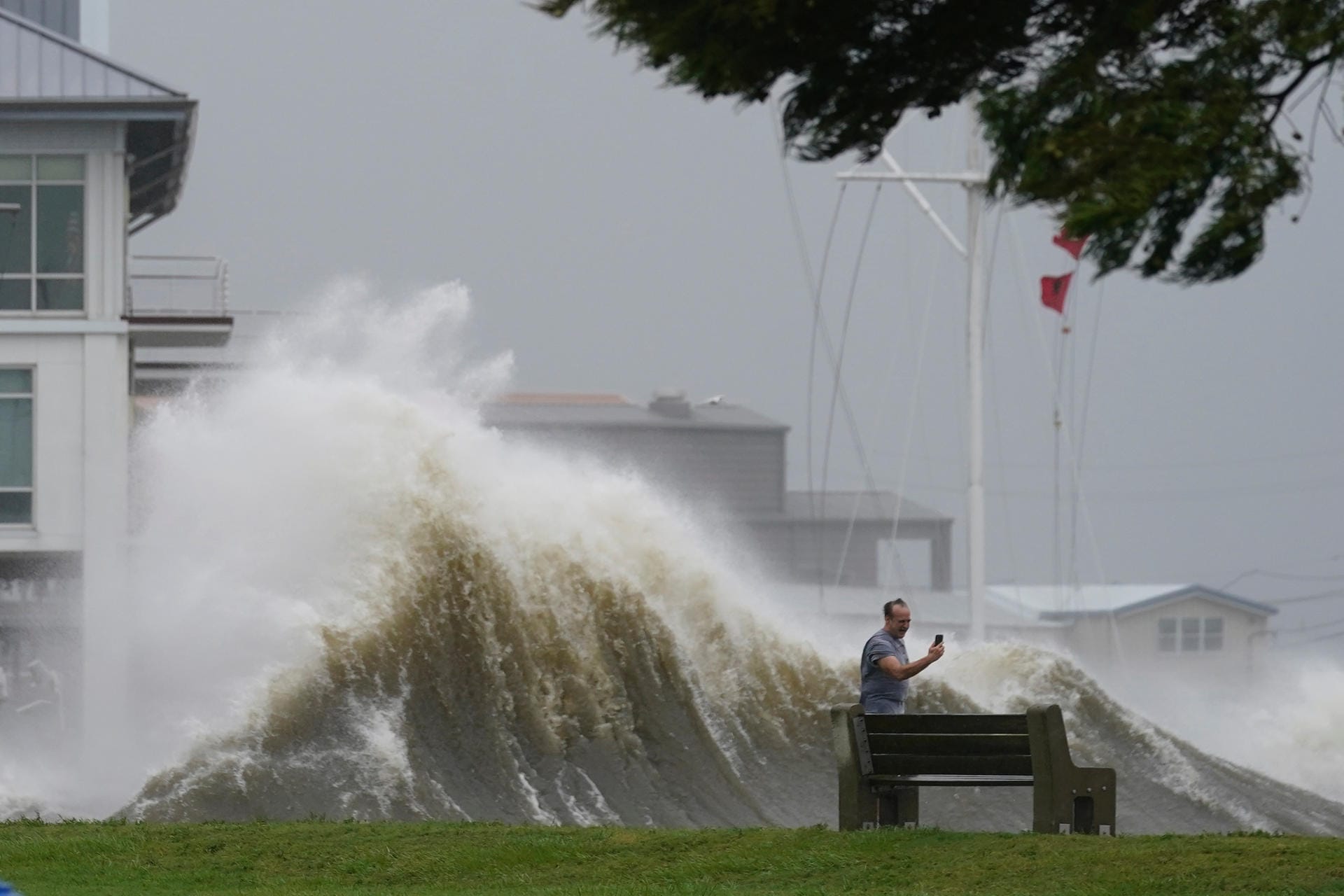 Hohe Wellen bei Lake Pontchartrain sind der Hintergrund für das Foto, das ein Mann macht.