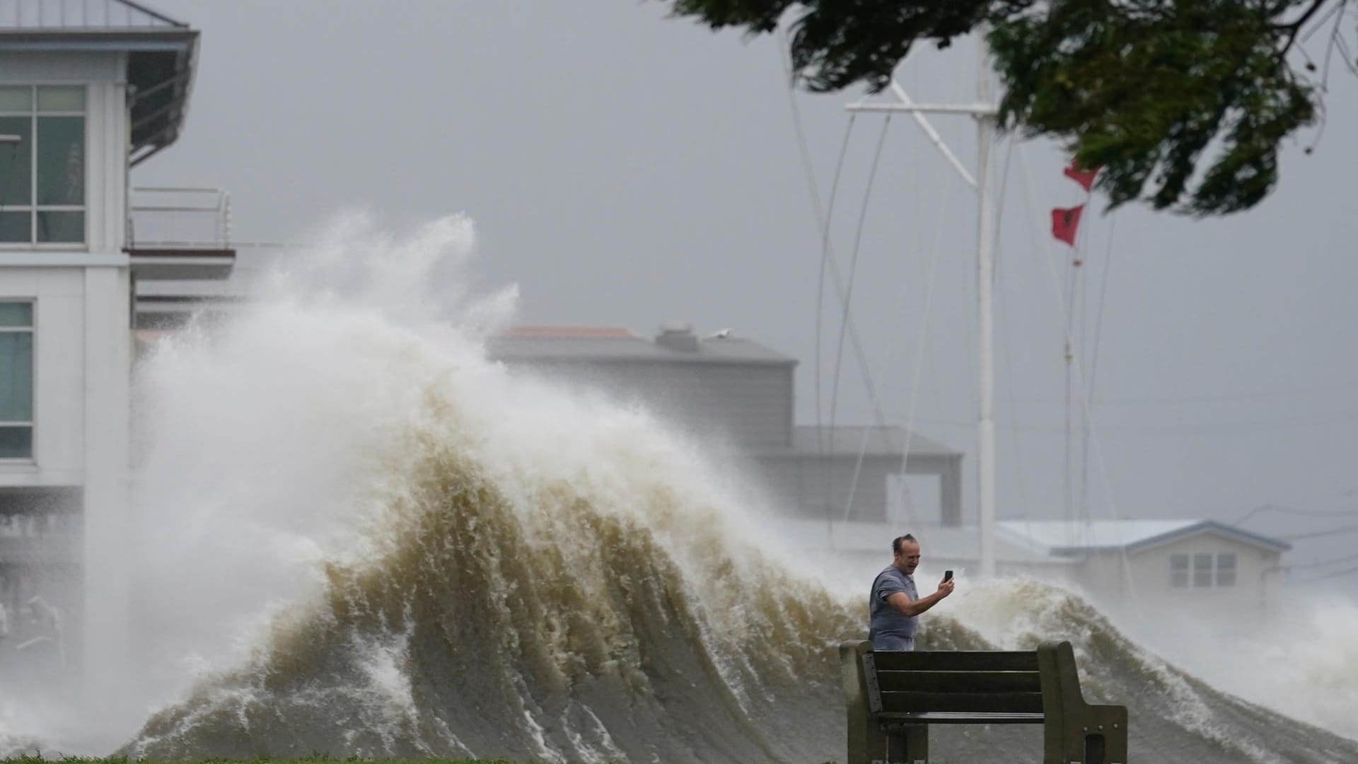 Hohe Wellen bei Lake Pontchartrain sind der Hintergrund für das Foto, das ein Mann macht.