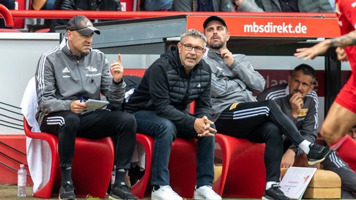 Unions Co-Trainer Markus Hoffmann, Trainer Urs Fischer und Co-Trainer Sebastian Bönig (l-r) sitzen auf Bank.