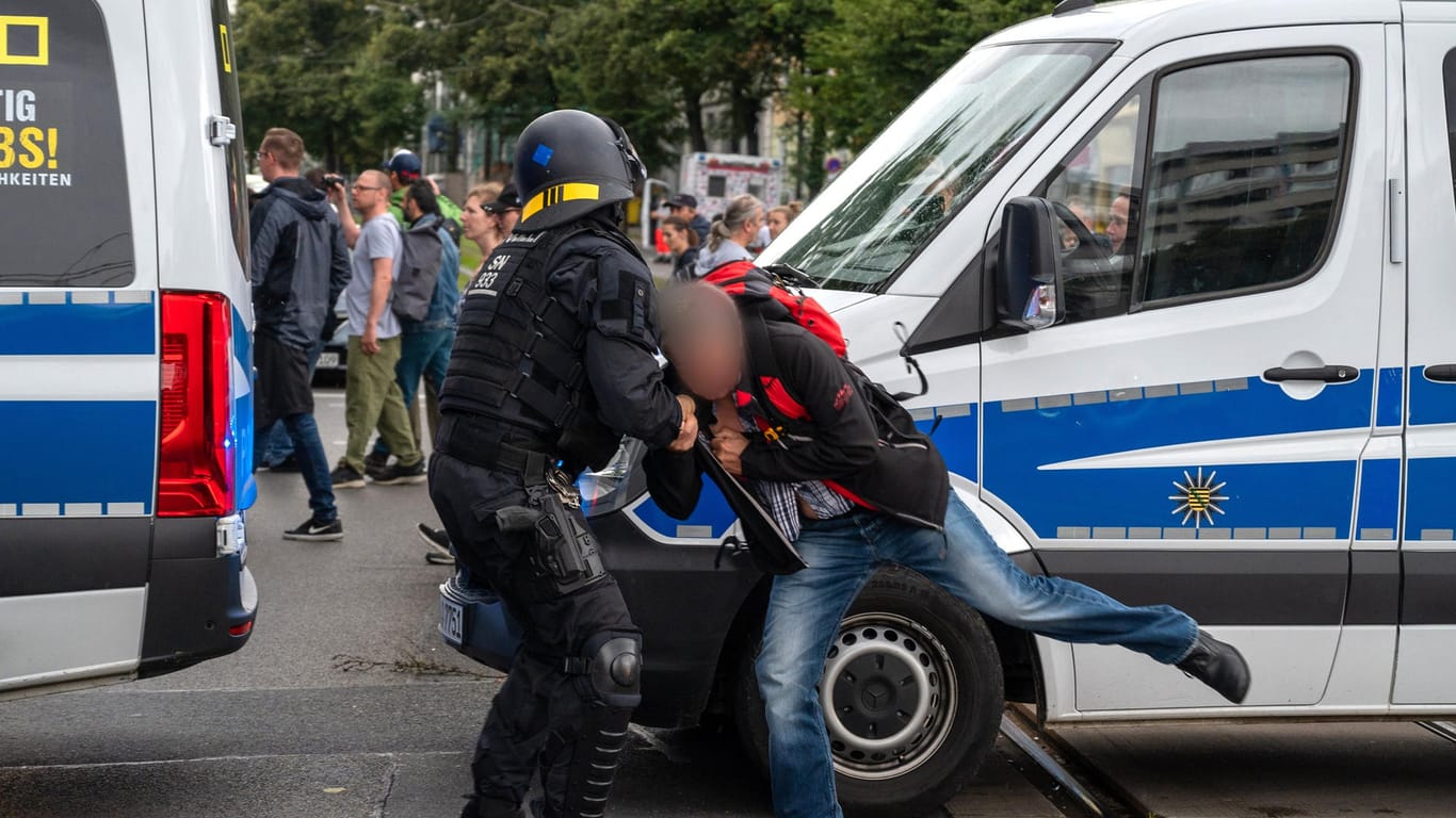 Ein Polizist hält einen Teilnehmer einer nicht genehmigten Demonstration. In Berlin waren am Wochenende Tausende unterwegs.