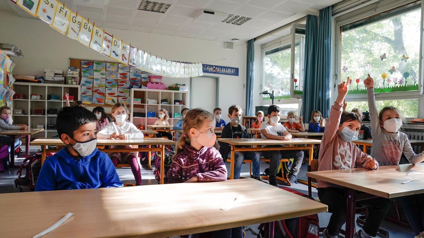 Schülerinnen und Schüler sitzen mit Masken in einem Klassenzimmer (Symbolbild): In der Hauptstadt ist ein Streit um Quarantäneregelungen in Schulen und Kitas entbrannt.