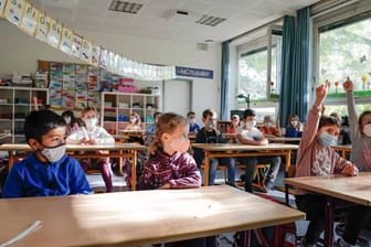 Schülerinnen und Schüler sitzen mit Masken in einem Klassenzimmer (Symbolbild): In der Hauptstadt ist ein Streit um Quarantäneregelungen in Schulen und Kitas entbrannt.