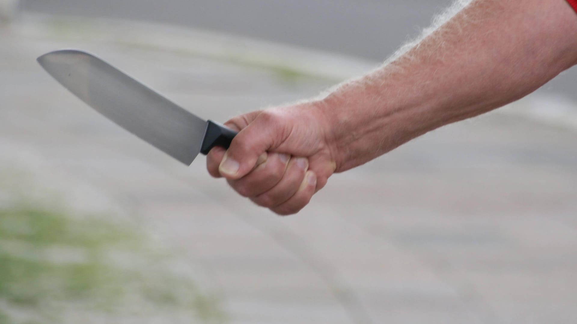 Ein Mann hält ein Messer auf der Straße (Symbolbild): In Essen wurde ein Grundschüler mit dem Messer bedroht und ausgeraubt. Ein Mann hält ein Messer auf der Straße (Symbolbild): In Essen wurde ein Grundschüler mit dem Messer bedroht und ausgeraubt.