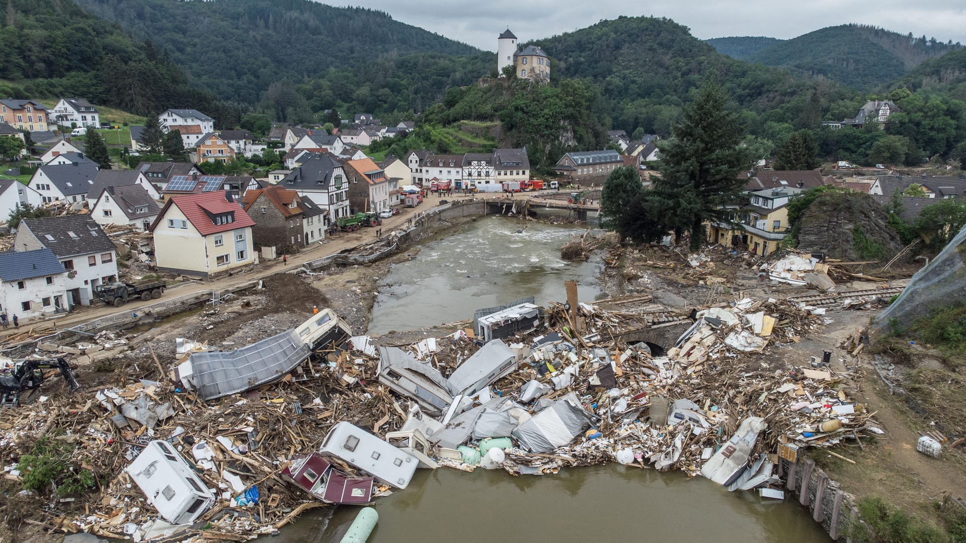 Altenahr: Meterhoch türmen sich Wohnwagen, Gastanks, Bäume und Schrott an einer Brücke über der Ahr.