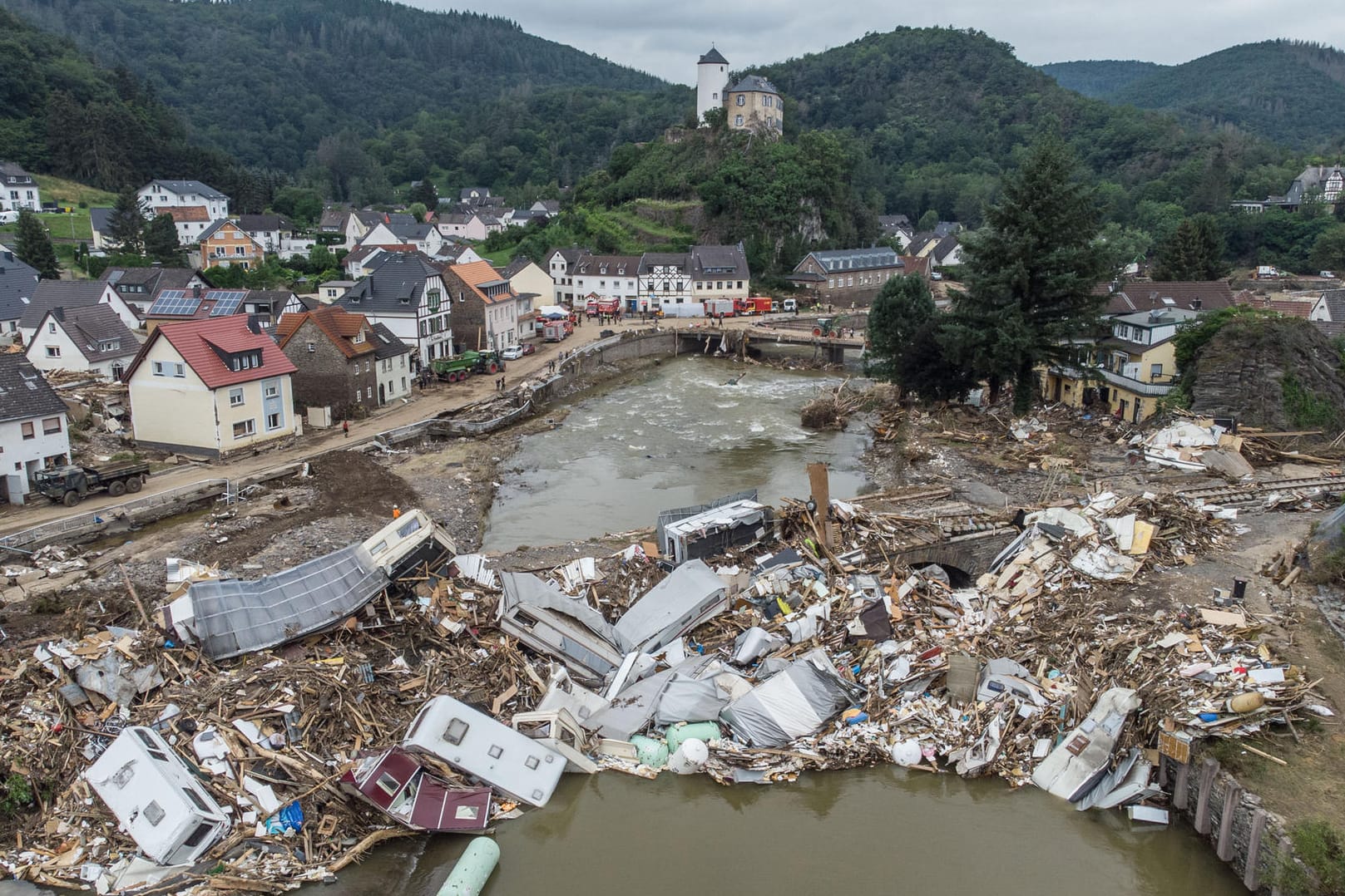 Altenahr: Meterhoch türmen sich Wohnwagen, Gastanks, Bäume und Schrott an einer Brücke über der Ahr.