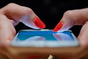 Eine Frau mit ihrem Smartphone. Verbraucherschützer beklagen hohe Preise für mobiles Internet in Deutschland.