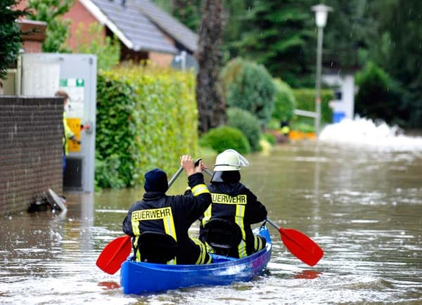 Unwetter über Deutschland: In Ochtrup-Langenhorst im Kreis Steinfurt kamen die Helfer in überfluteten Regionen teils nur noch mit dem Kanu voran. (
