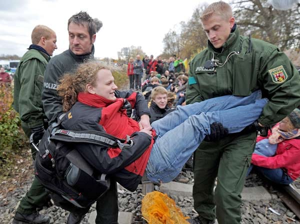 Castor-Transport: Schließlich müssen Polizisten die Demonstranten in Berg von den Gleisen tragen. Wegen der Sitzblockaden wird der Castor-Transport umgeleitet. Über Kehl fährt er nach Deutschland. Unterdessen versuchen Aktivisten in der Nähe von Gorleben die Straße, über die der Castor fahren soll, zu untergraben. Die Polizei greift mit Gewalt durch. ( Castor-Transport: Schließlich müssen Polizisten die Demonstranten in Berg von den Gleisen tragen. Wegen der Sitzblockaden wird der Castor-Transport umgeleitet. Über Kehl fährt er nach Deutschland. Unterdessen versuchen Aktivisten in der Nähe von Gorleben die Straße, über die der Castor fahren soll, zu untergraben. Die Polizei greift mit Gewalt durch. (