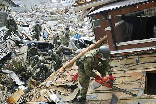 Soldaten der japanischen Selbstverteidigungsstreitkräfte suchen am 25. März 2011 mit bloßen Händen und einer Motorsäge nach Opfern des Tsunami in Onagawa. (