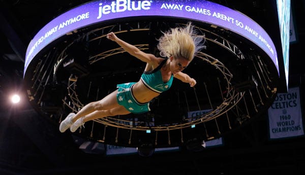 Diese Cheerleaderin der Boston Celtics ist nach einem Wurf in die Luft auf Supermans Spuren. (