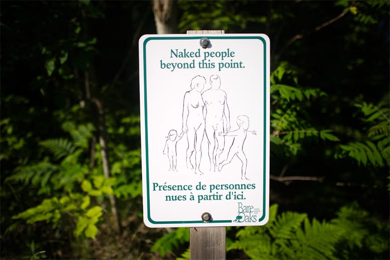 Am Eingang des Parks steht ein Schild mit den Hinweis "Nackte Menschen hinter dieser Stelle".