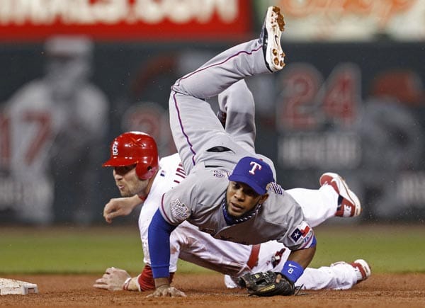 Sieht aus wie Twister im Infield, ist aber der Kampf um die World Series. Elvis Andrus von den Texas Rangers fliegt über Matt Holliday von den St. Louis Cardinals.